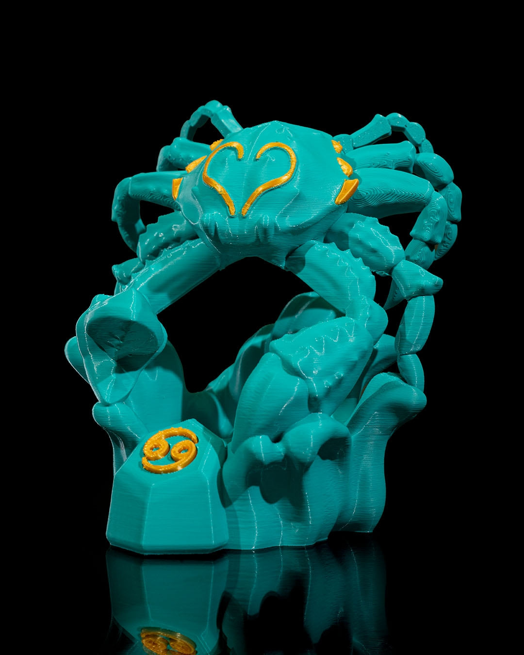 Türkis-gelbe Krebs-Skulptur in dekorativer Szene auf einem Tisch vor einem goldenen Rahmen – stimmungsvolle Wohnambiente-Darstellung.