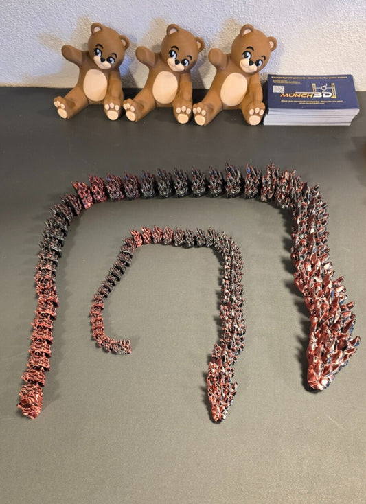 Große und kleine Drachen-Schlange nebeneinander auf Tisch

