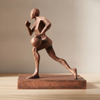 Basketball-Statue in Kupfer-Bronze-Optik, Seitenansicht der Dribbel-Pose mit Ball auf Holzoberfläche, weich unscharfer warmer Hintergrund – Münch3D