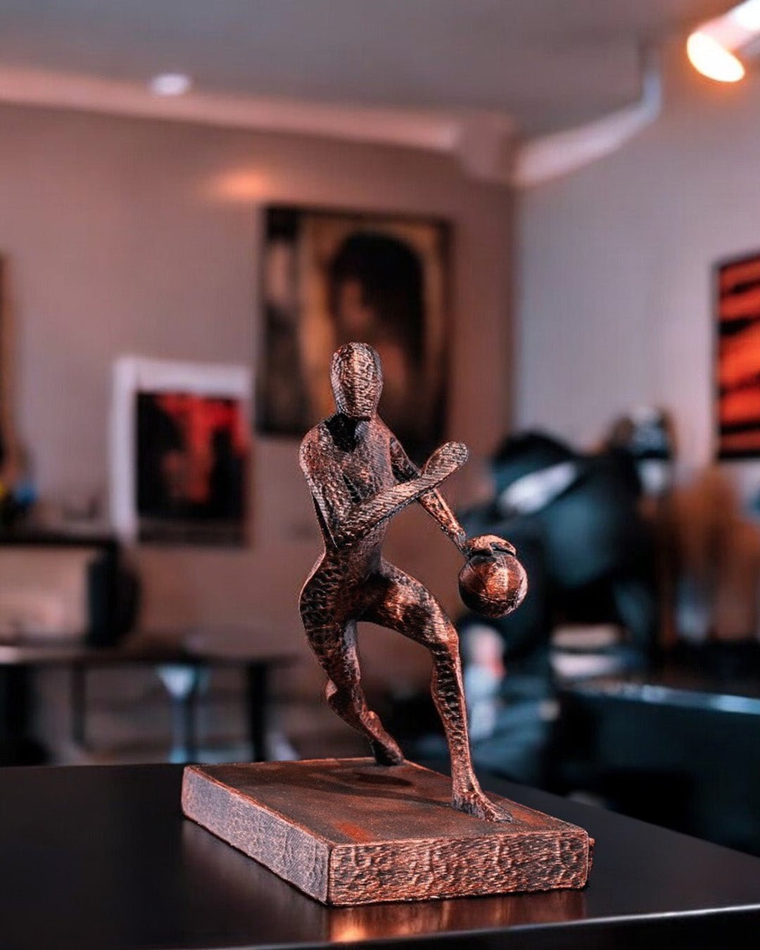 Handbemalte Basketball-Statue in Kupfer-Bronze-Optik – Lifestyle-Aufnahme im Wohnzimmer mit Bildern im Hintergrund