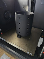 Echtfoto frisch gedruckt – schwarzer perforierter Besteckhalter auf dem Druckbett eines 3D-Druckers, keine Farbvarianten gezeigt