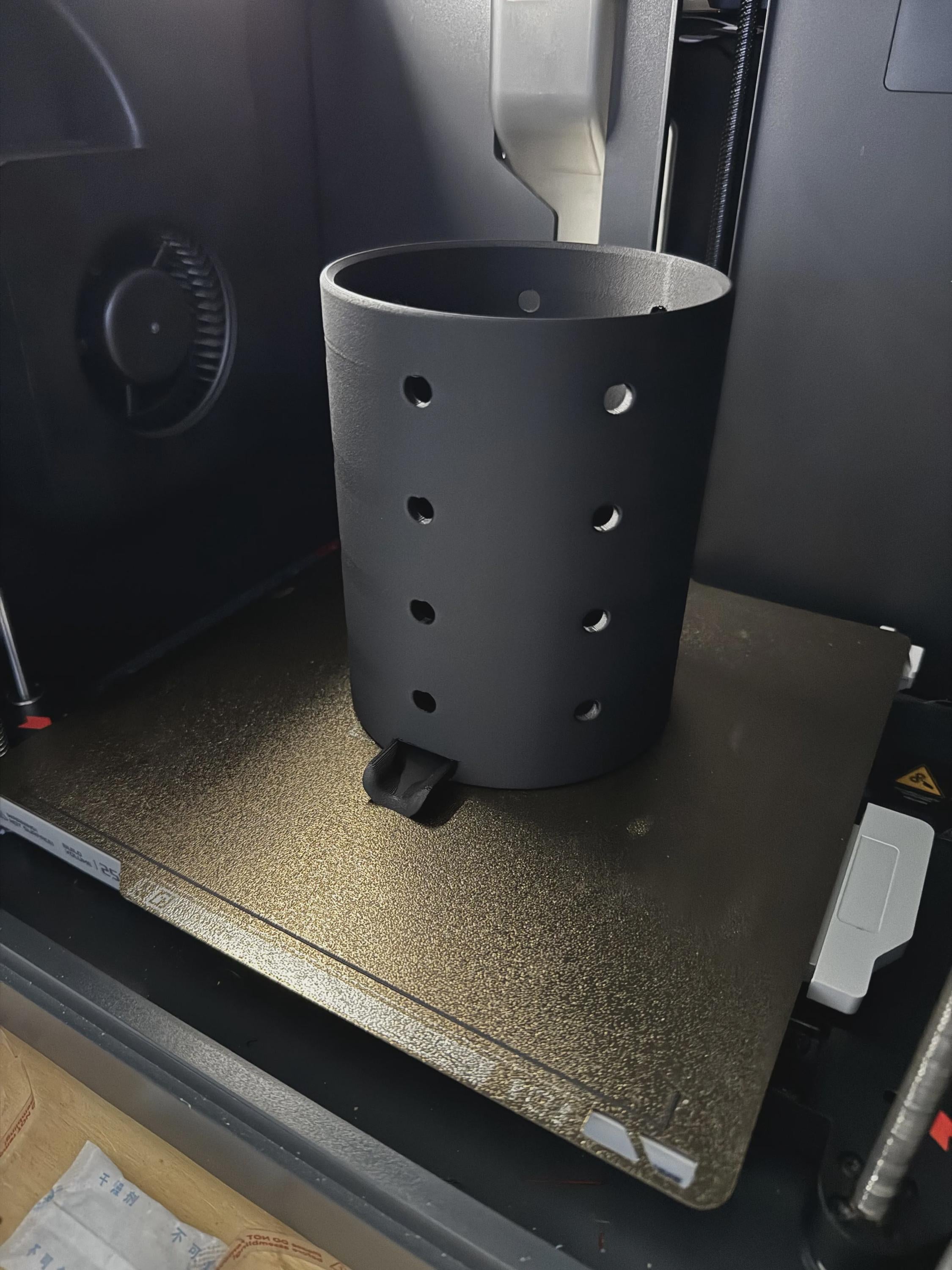 Echtfoto frisch gedruckt – schwarzer perforierter Besteckhalter auf dem Druckbett eines 3D-Druckers, keine Farbvarianten gezeigt