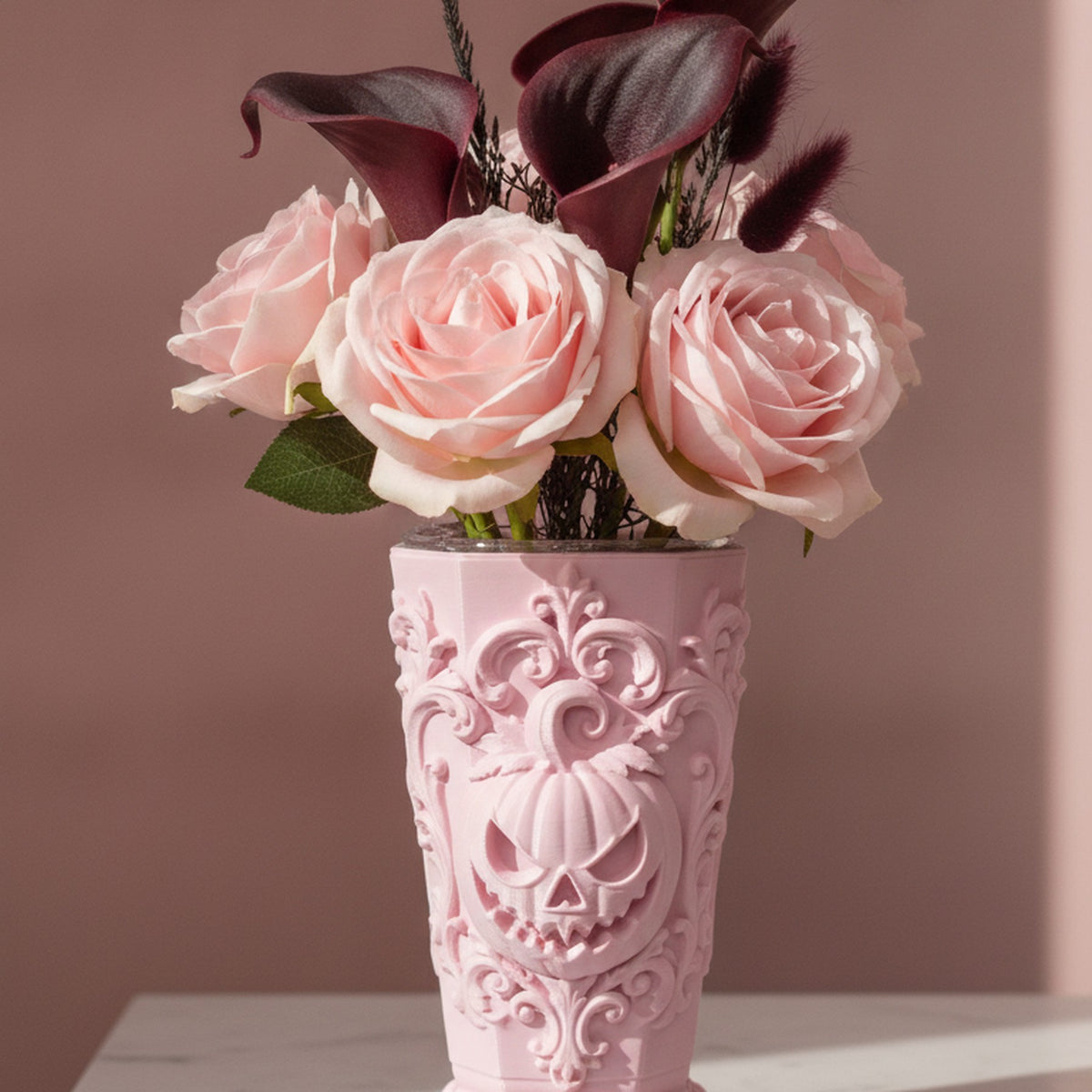 Rosa Kürbisvase gefüllt mit rosa Rosen und dunklen Calla-Lilien auf einem weißen Marmortisch