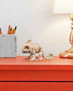 Skelett-Chamäleon-Figur auf orangefarbenem Schreibtisch neben Stifteköcher und Tischlampe, echter Größenvergleich im Raum