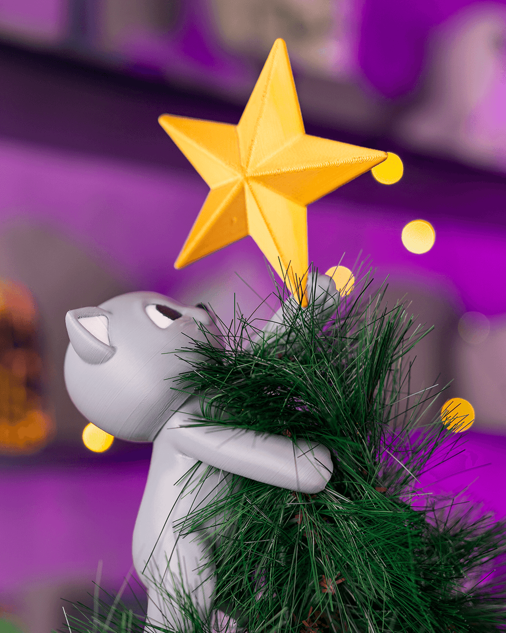 Christbaumspitze Katze kletternd, Detailansicht Kopf und Pfoten am Baumwipfel, lila Bokeh-Hintergrund – Münch3D