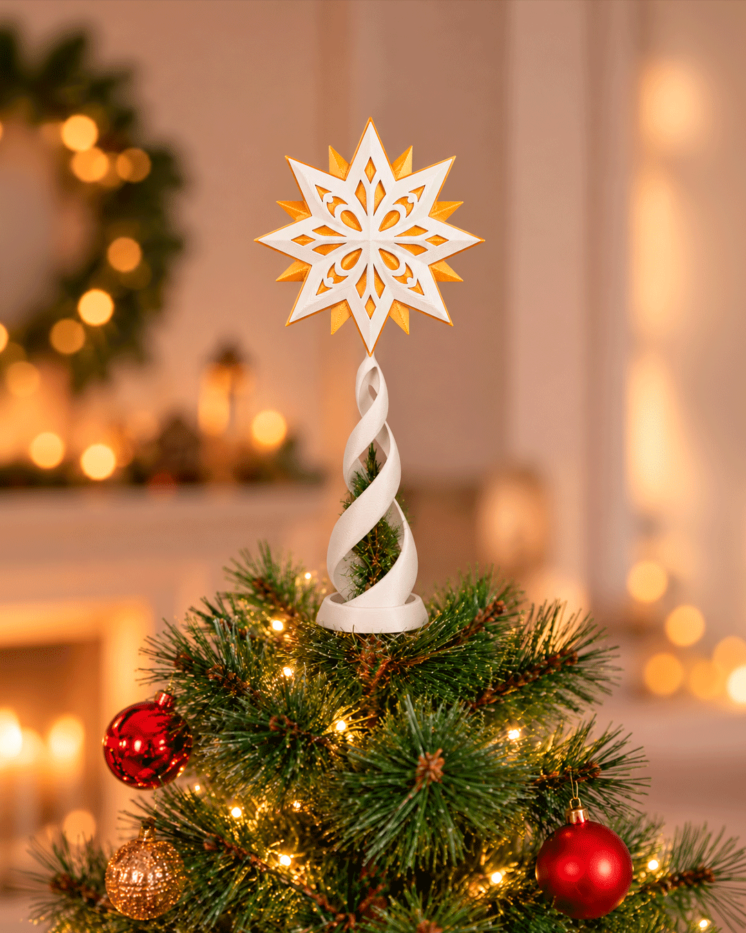 Christbaumspitze mit weiß-goldenem Stern und weißer Spirale auf einem Weihnachtsbaum mit Lichterkette sowie roten und goldenen Kugeln, warmes Zimmer mit Girlande im Hintergrund