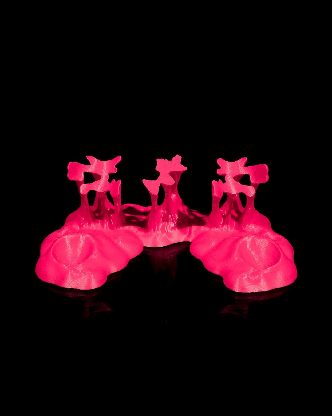 Leerer Controller-Ständer im Sticky-Splash-Design in Pink, Frontalansicht ohne Controller vor schwarzem Hintergrund