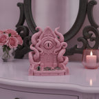 Rosa Cthulhu-Schmuckschale mit Ringen und Fledermaus-Anhängern in der Schale, auf einem Frisiertisch vor einem verzierten Spiegel mit Rosen