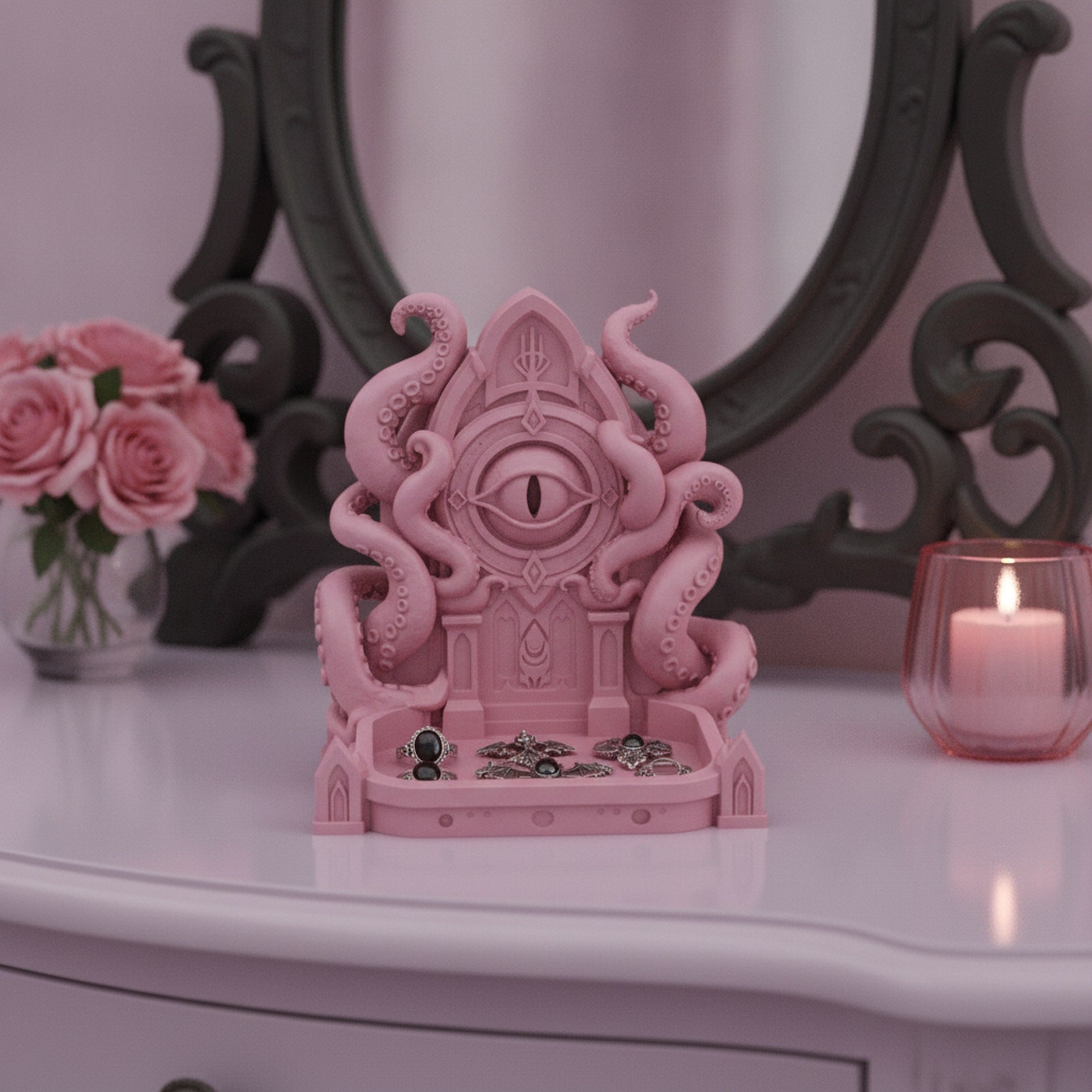 Rosa Cthulhu-Schmuckschale mit Ringen und Fledermaus-Anhängern in der Schale, auf einem Frisiertisch vor einem verzierten Spiegel mit Rosen
