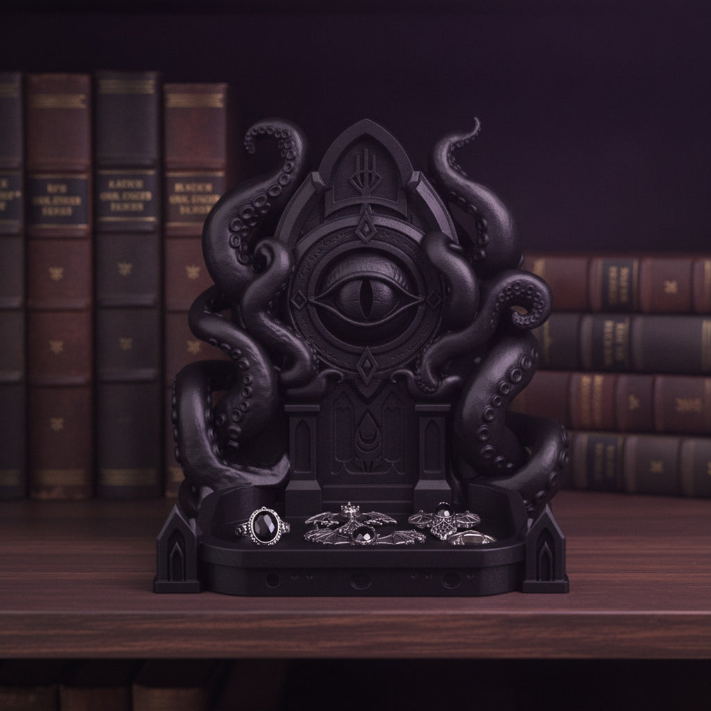 Schwarze Cthulhu-Schmuckschale mit Ringen und Fledermaus-Ohrringen in der Ablageschale, auf einem Bücherregal mit ledergebundenen Büchern