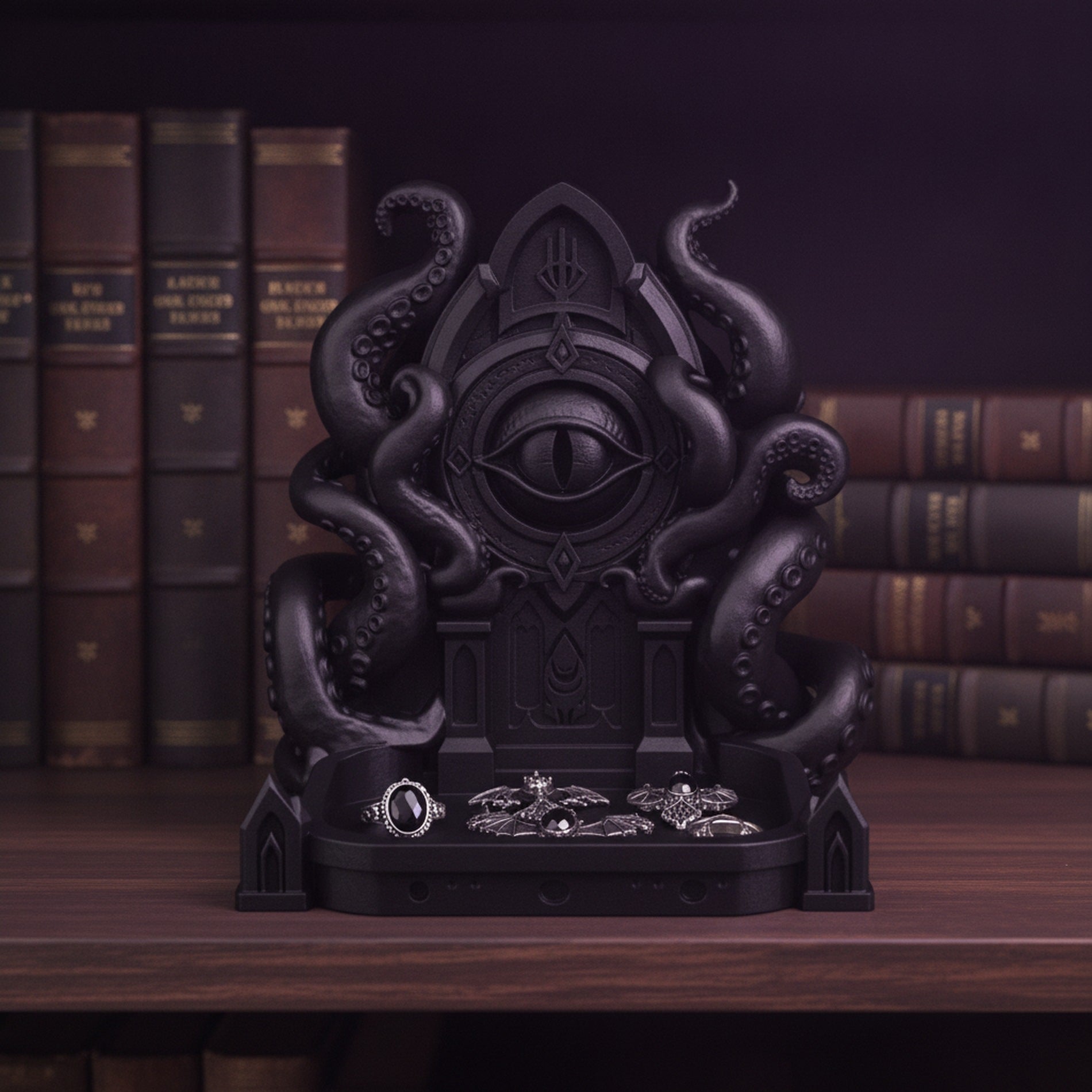 Schwarze Cthulhu-Schmuckschale mit Ringen und Fledermaus-Ohrringen in der Ablageschale, auf einem Bücherregal mit ledergebundenen Büchern
