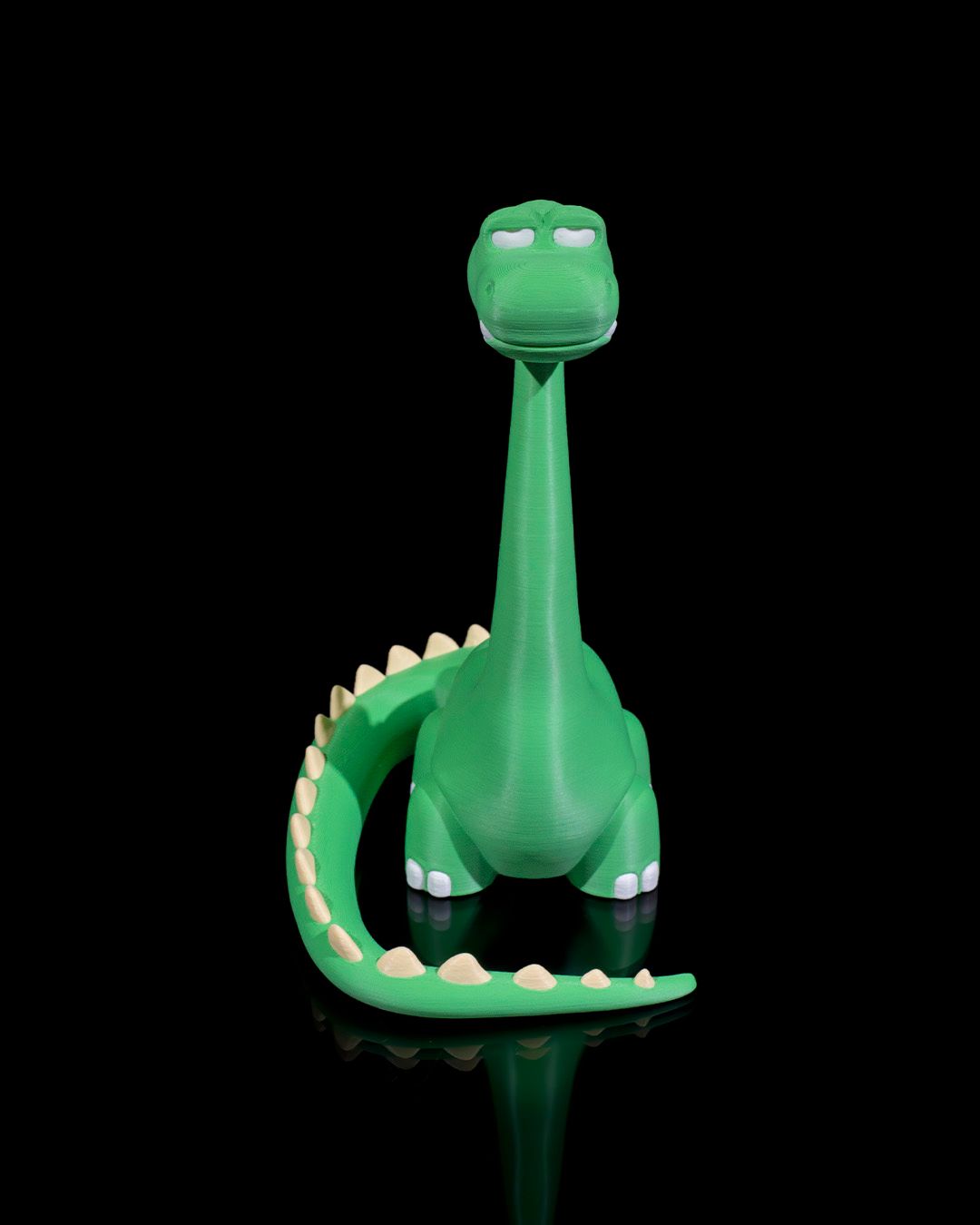 Grüner Dino-Handyhalter ohne Smartphone, Frontalansicht mit langem Hals und gezähntem Schwanzring vor schwarzem Hintergrund