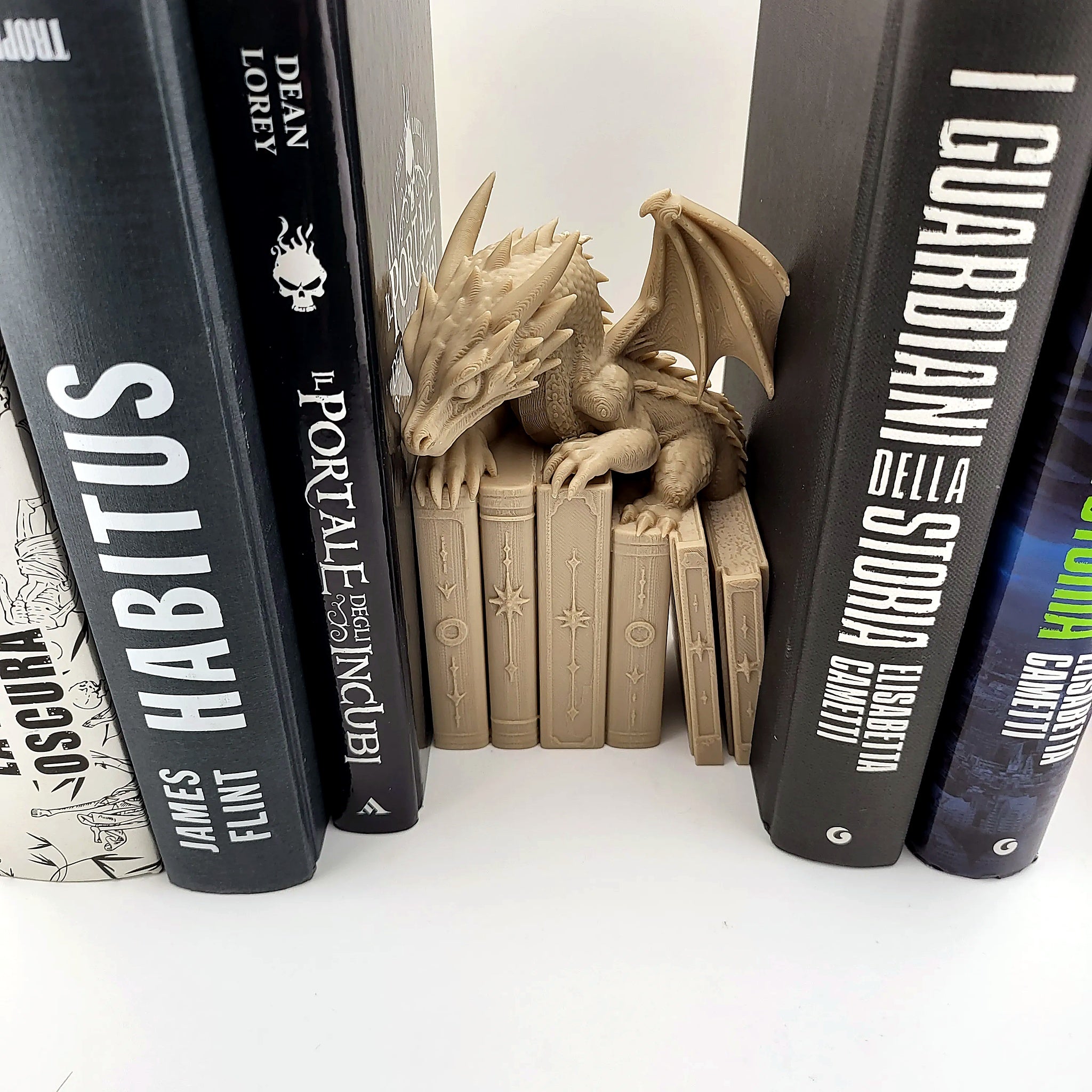 Drachen-Buchstütze in Knochenweiß, zentrierte Frontalansicht auf Bücherstapel