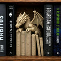 Drachen-Buchstütze in Knochenweiß im Holzregal, dramatisch inszeniert zwischen Büchern