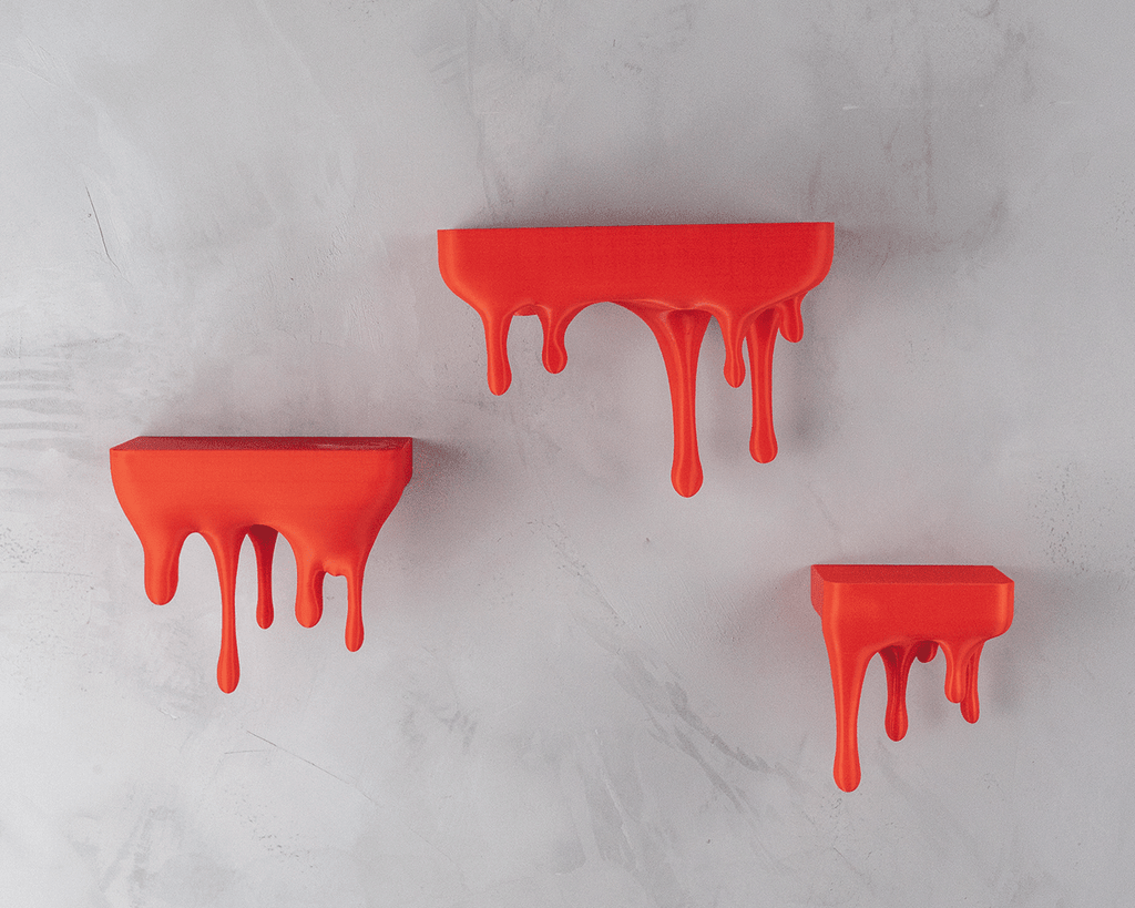 Drei Wandregale im Tropfen-Design in Rot-Orange, montiert an heller Steinwand, ohne Deko