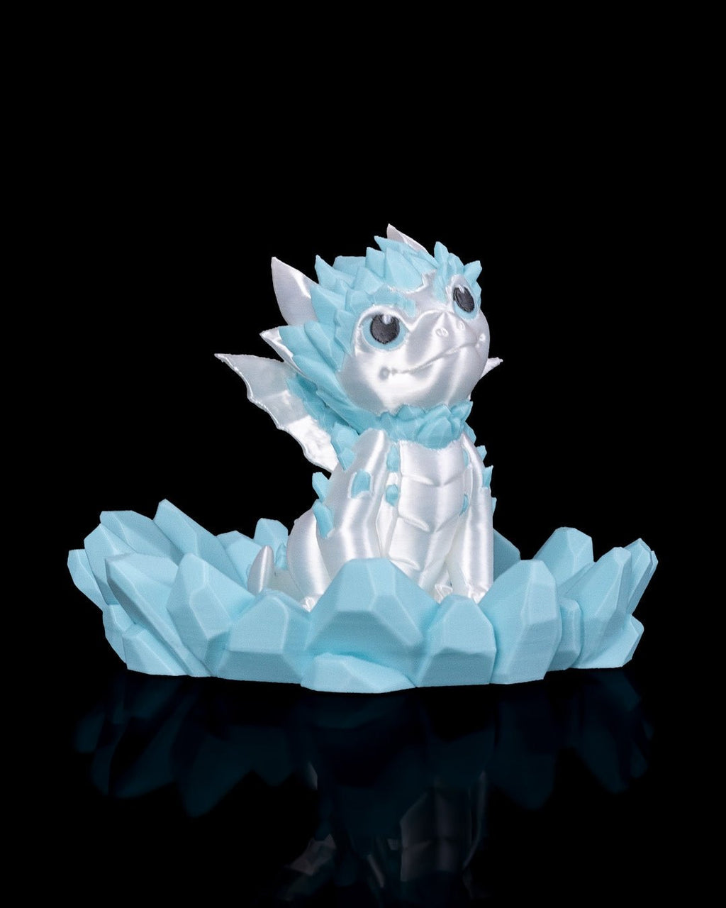 Weiß-blauer Eisdrache, sitzend auf hellblauer Kristallbasis, Frontalansicht vor schwarzem Hintergrund