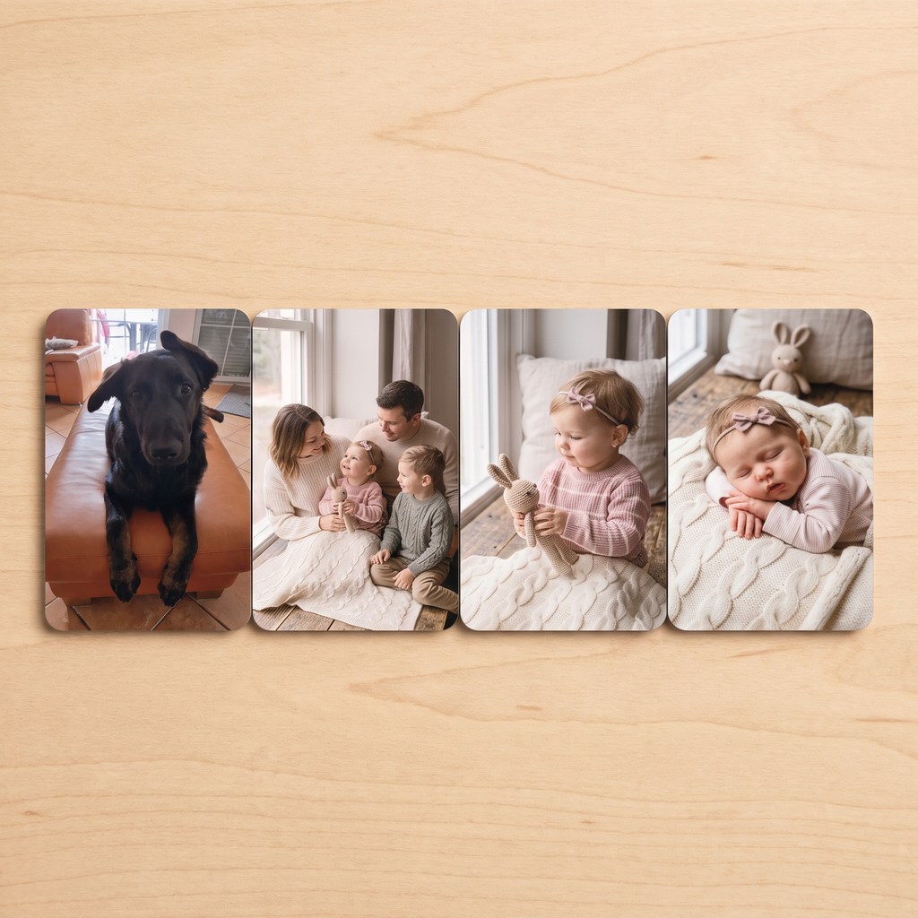 Vier Foto-Kühlschrankmagnete nebeneinander auf Holztisch: schwarzer Hund, Familie mit zwei Kindern, Mädchen mit Häschen-Kuscheltier, schlafendes Baby mit Haarschleife