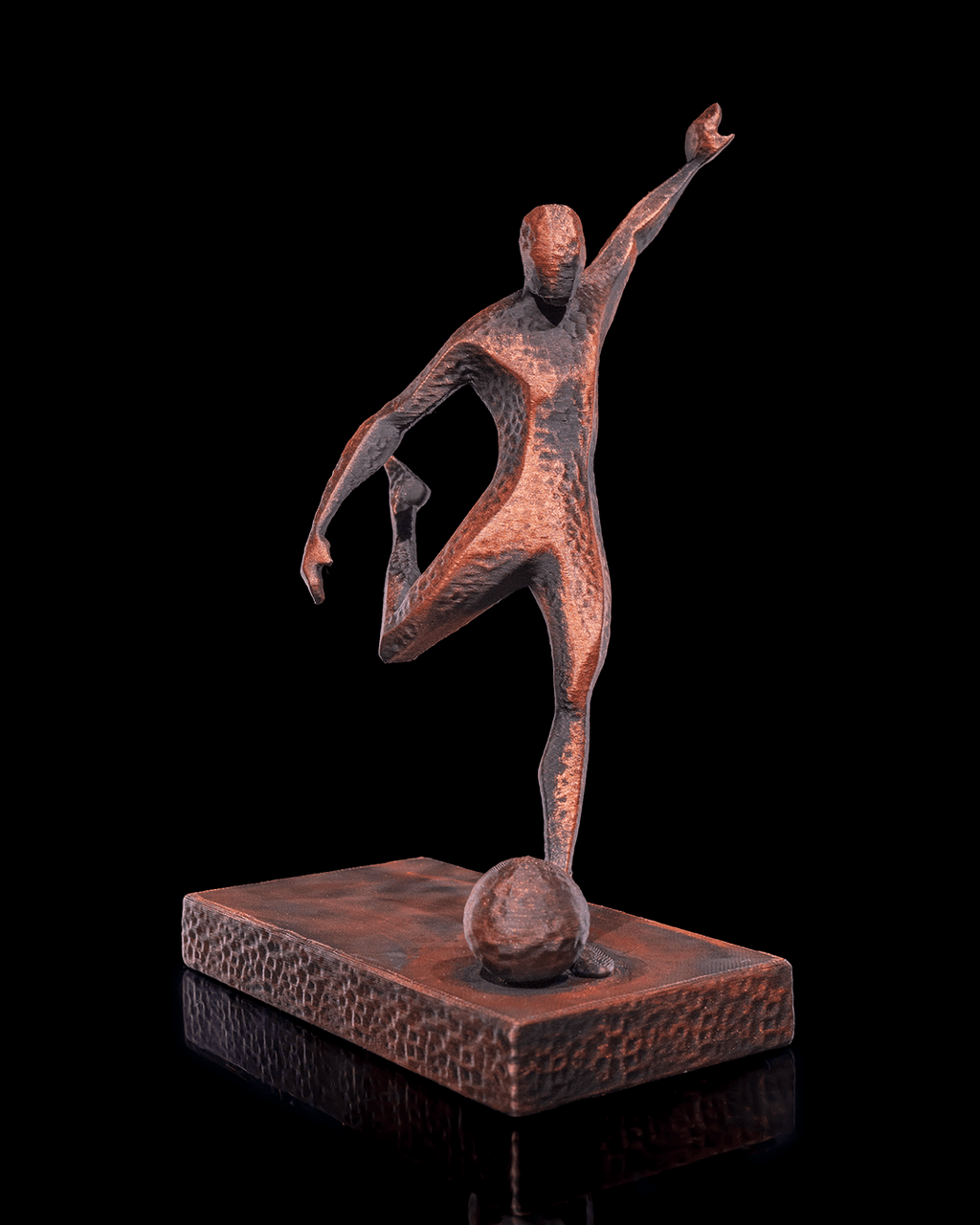 Fußballspieler-Statue in Kupfer-Optik, Frontalansicht beim Schuss mit erhobenem Arm vor schwarzem Hintergrund – Münch3D