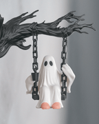 Nahaufnahme der Geist-Figur auf der Kettenschaukel mit Tasse in der einen und Kette in der anderen Hand