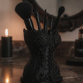 Gothic-Korsett-Pinselhalter in Schwarz aus 3/4-Winkel, bestückt mit Make-up-Pinseln vor einem Spiegel