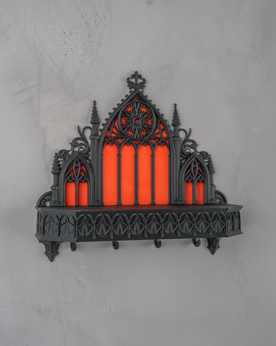 Gotischer Schlüsselhalter Kathedrale nahezu frontal an heller Wand, Rosettenfenster und gotische Spitzbögen mittig im Blick, leere Schlüsselhaken