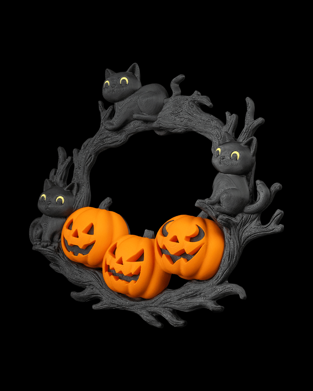 Halloween-Türkranz mit drei schwarzen Katzenfiguren und drei Kürbissen mit Grinsegesichtern auf Astwerk, Ansicht leicht von oben vor schwarzem Hintergrund