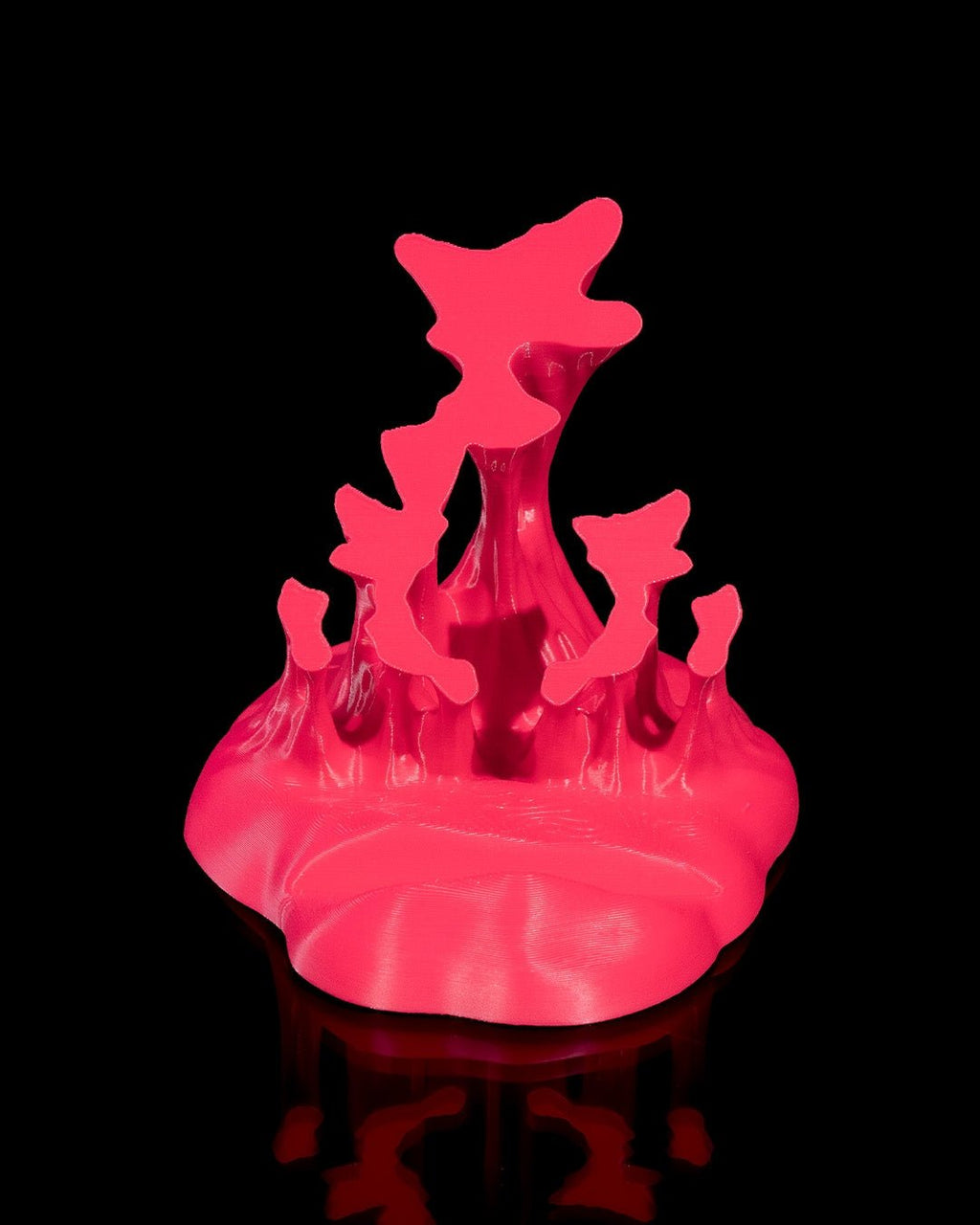 Neonpinker Splash-Handyhalter ohne Smartphone, Frontalansicht der durchbrochenen Spritzform vor schwarzem Hintergrund