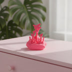 Neonpinker Splash-Handyhalter ohne Smartphone auf pastellrosa Kommode, unscharfe Zimmerpflanze im Hintergrund