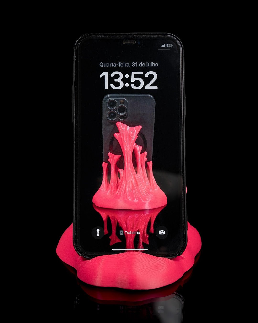Neonpinker Splash-Handyhalter mit eingestecktem Smartphone in Hülle, Frontalansicht vor schwarzem Hintergrund
