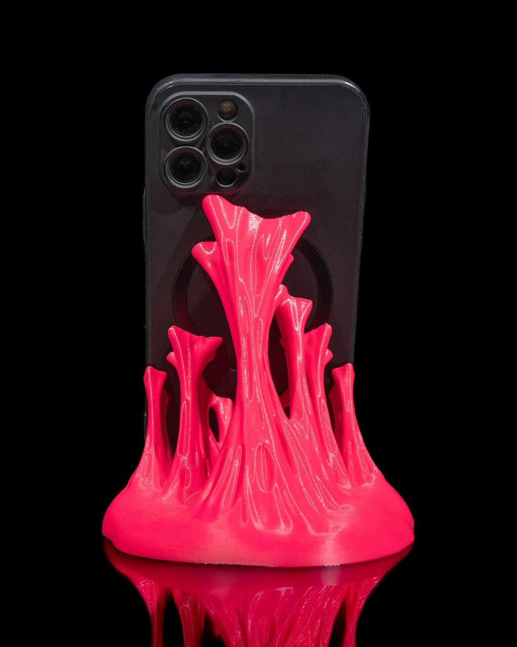 Neonpinker Splash-Handyhalter mit eingestecktem Smartphone, Rückseite des Handys mit Kamera sichtbar, schwarzer Hintergrund
