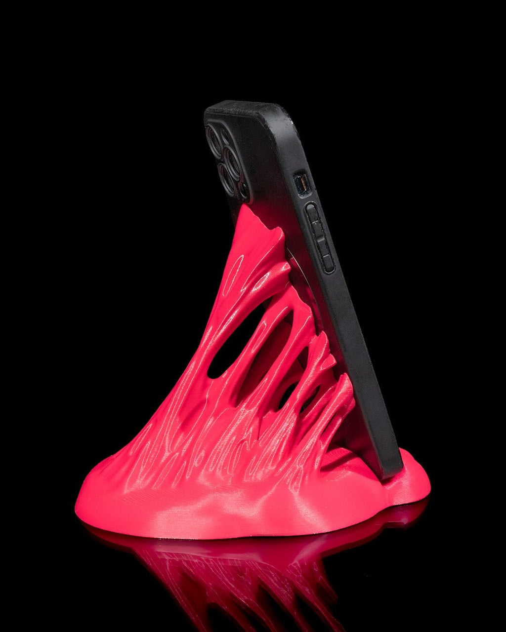 Neonpinker Splash-Handyhalter mit eingestecktem Smartphone, schräge Seitenansicht mit durchbrochener Struktur