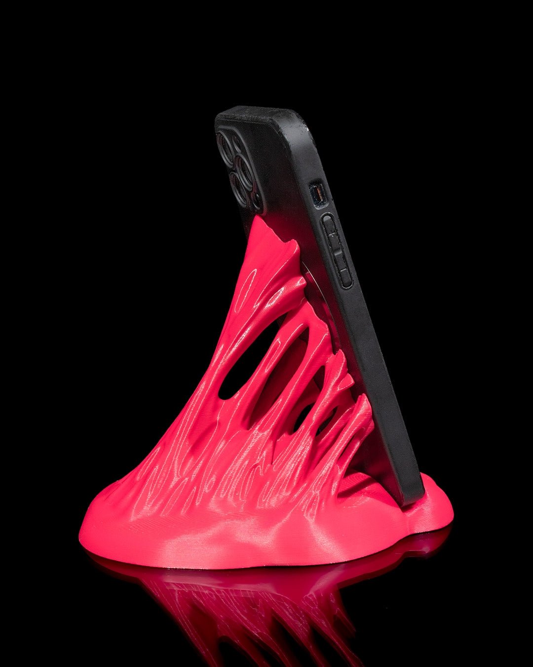Neonpinker Splash-Handyhalter mit eingestecktem Smartphone, schräge Seitenansicht mit durchbrochener Struktur