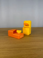 Beide Farbkombinationen des Heizungsentlüfter-Schlüssel-Sets nebeneinander auf einem Holztisch, links Orange mit gelbem Schlüssel, rechts Gelb mit orangem Schlüssel