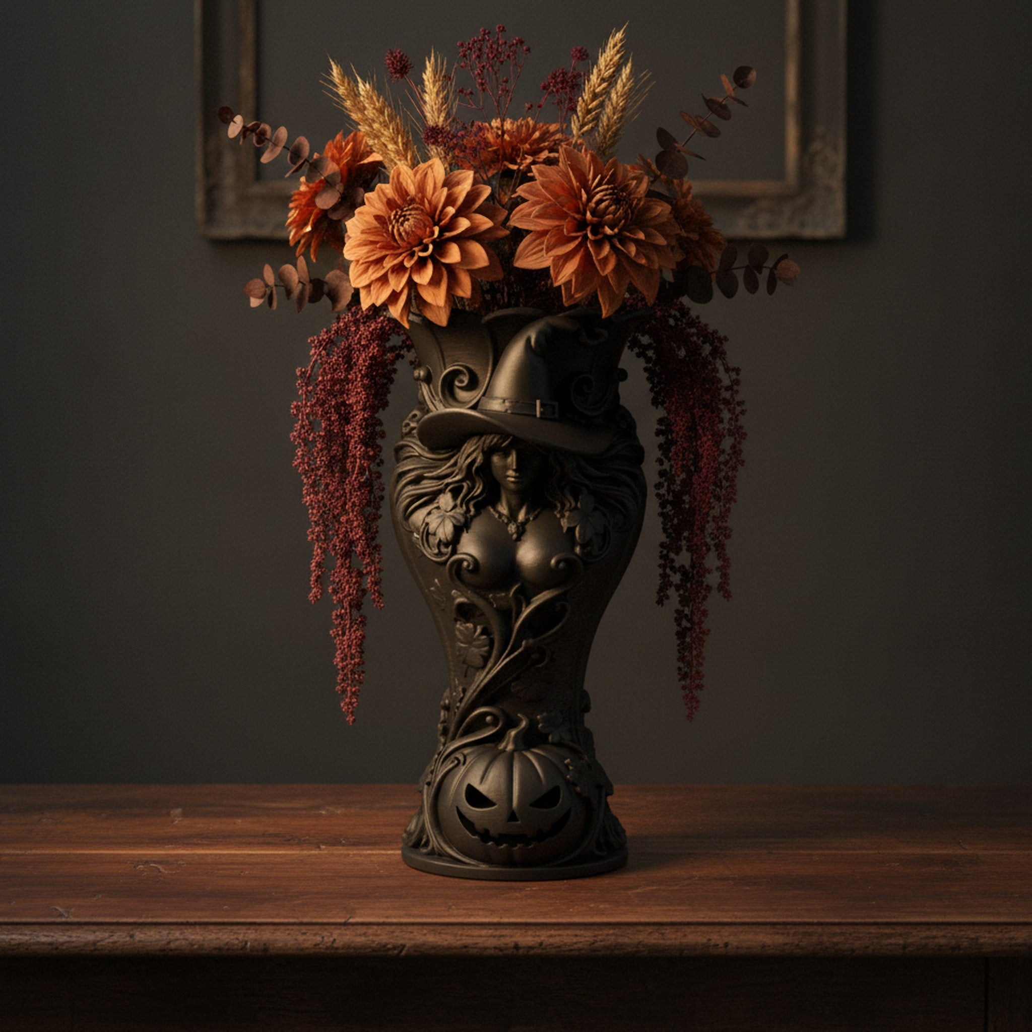 Schwarze Hexen-Kürbis-Vase mit Hexenhut-Relief und Herbstblumenstrauß aus Dahlien und Trockengräsern, Frontalansicht vor dunklem Wandrahmen
