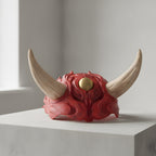 Imposante Oni-Maske 48 cm, handbemalt in Rot mit cremefarbenen Hörnern und goldenem Auge, Nahaufnahme auf heller Holzregal-Kante vor schlichter Wand – Münch3D
