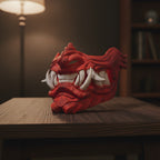 Imposante Oni-Maske 48 cm, handbemalt in Rot mit cremefarbenen Reißzähnen, Ansicht von unten mit Fokus auf Maul und Zähne, dunkler Beistelltisch mit Stehlampe im Hintergrund – Münch3D