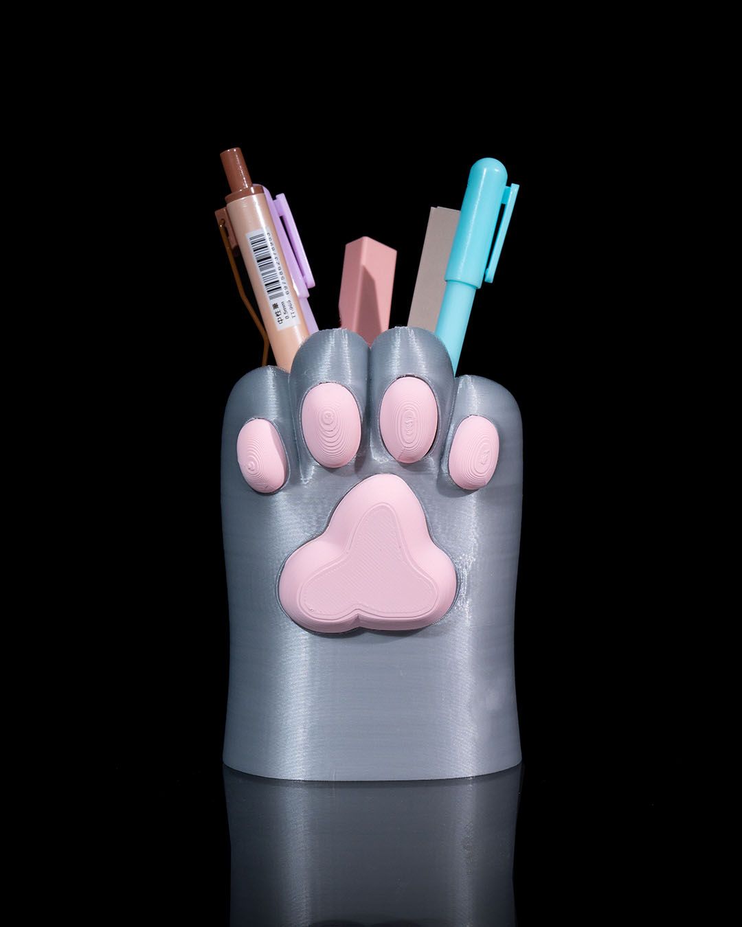 Stiftehalter in Katzenpfotenform in Grau mit rosa Ballen, Frontalansicht mit bunten Stiften und Textmarker befüllt