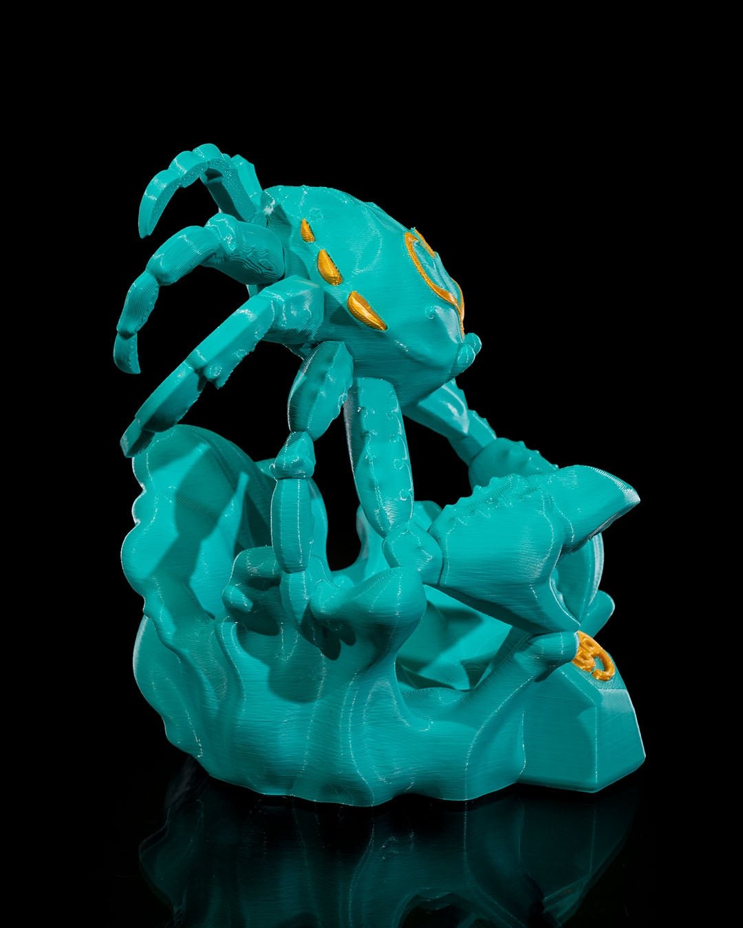Türkise Krebs-Skulptur, seitliche Ansicht mit ausgestreckten Scheren und Beinen über der Wellenbasis, schwarzer Hintergrund