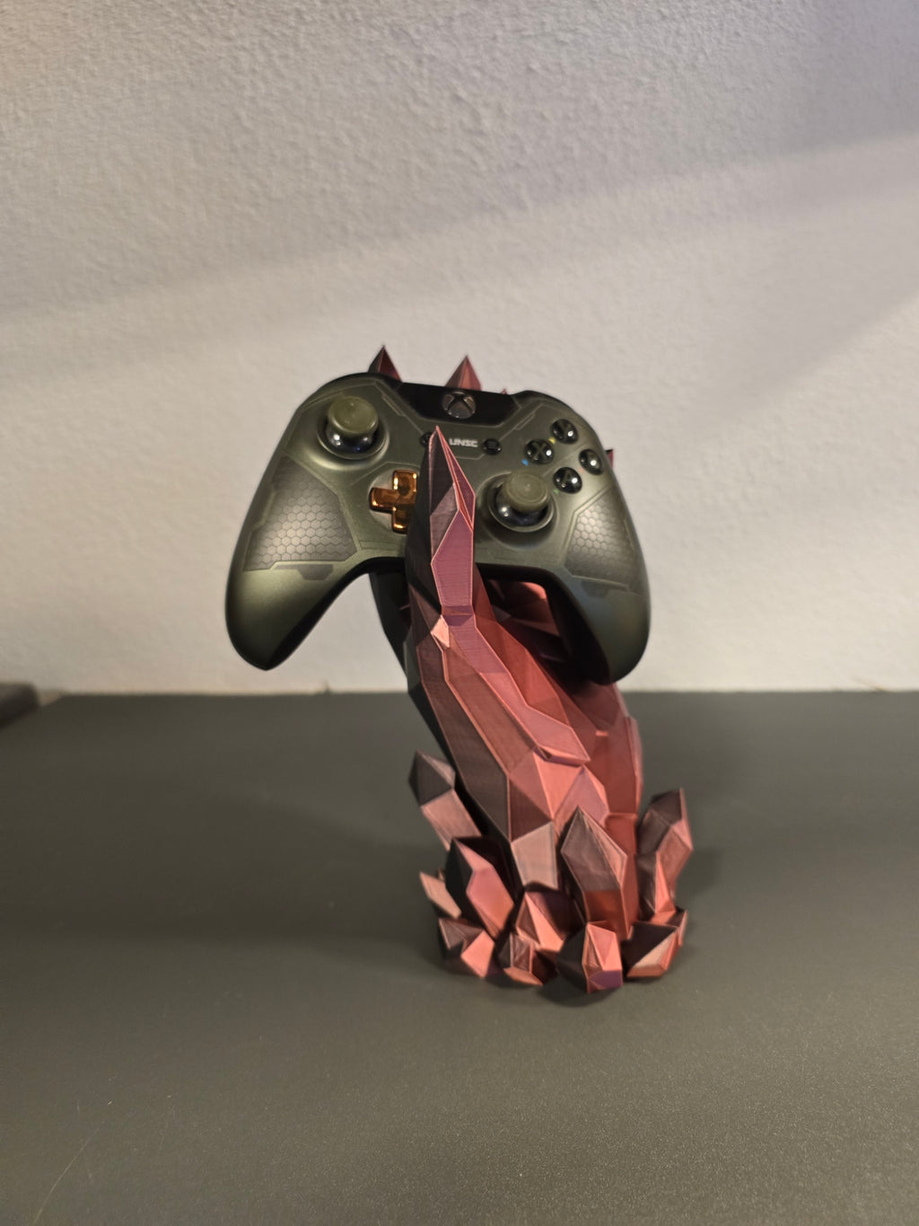Kristallhand-Controllerhalter in Kupfer-Rot mit eingesetztem olivgrünem Gaming-Controller, Frontalansicht