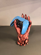 Kristallhand-Controllerhalter in Kupfer-Rot mit eingesetztem blauem Gaming-Controller, leicht andere Frontalansicht vor Wohnzimmerwand