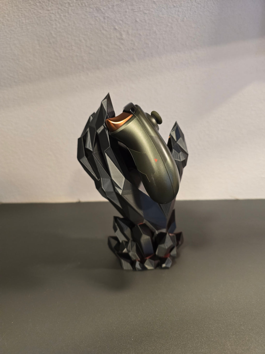 Kristallhand-Controllerhalter in Schwarz-Grau mit eingesetztem olivgrünem Gaming-Controller, seitliche Ansicht