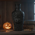 Schwarze Gothic Deko-Flasche mit Kürbis-Relief, Mondsichel und Sternen, Frontansicht auf dunklem Holzregal mit Halloween-Kürbis und Büchern