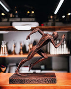 Läufer Statue handbemalt in Kupfer-Bronze-Optik, Sprint-Pose – Lifestyle-Aufnahme vor Regal mit Pokalen