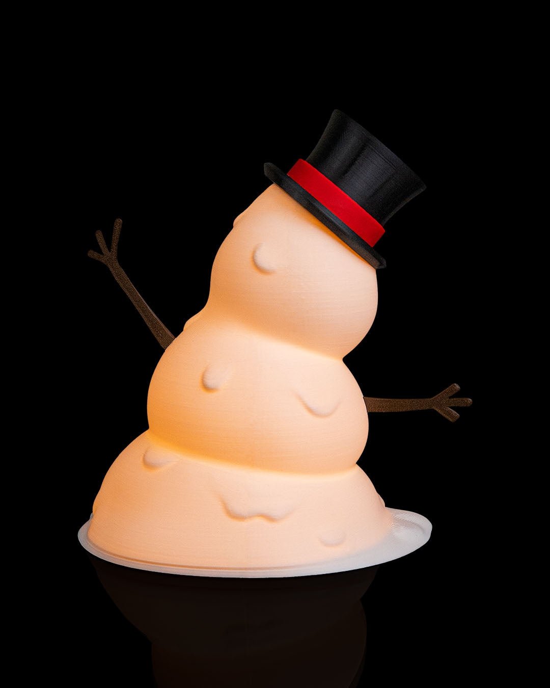 LED-Tischlampe Schneemann von schräg unten fotografiert mit Zylinderhut, Karottennase und Lächeln, vor schwarzem Hintergrund