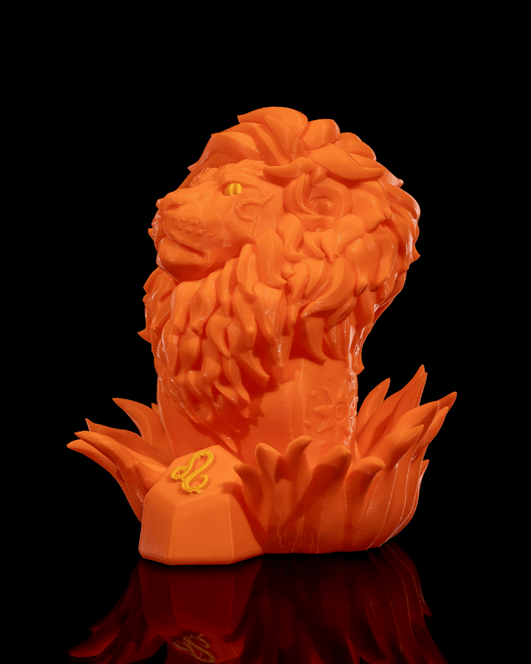 Löwen-Figur in Orange, leicht gedrehte Ansicht mit sichtbarem Sonnenmotiv auf der Brust und Löwe-Symbol am Sockel, vor schwarzem Hintergrund