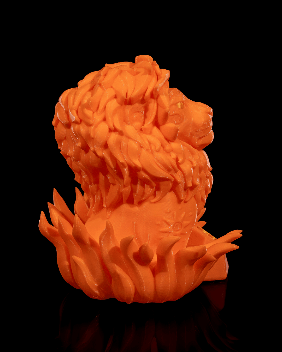Löwen-Figur in Orange aus schräger Seitenansicht von hinten, Mähne und Flammensockel im Fokus, Gesicht am Bildrand angeschnitten, vor schwarzem Hintergrund