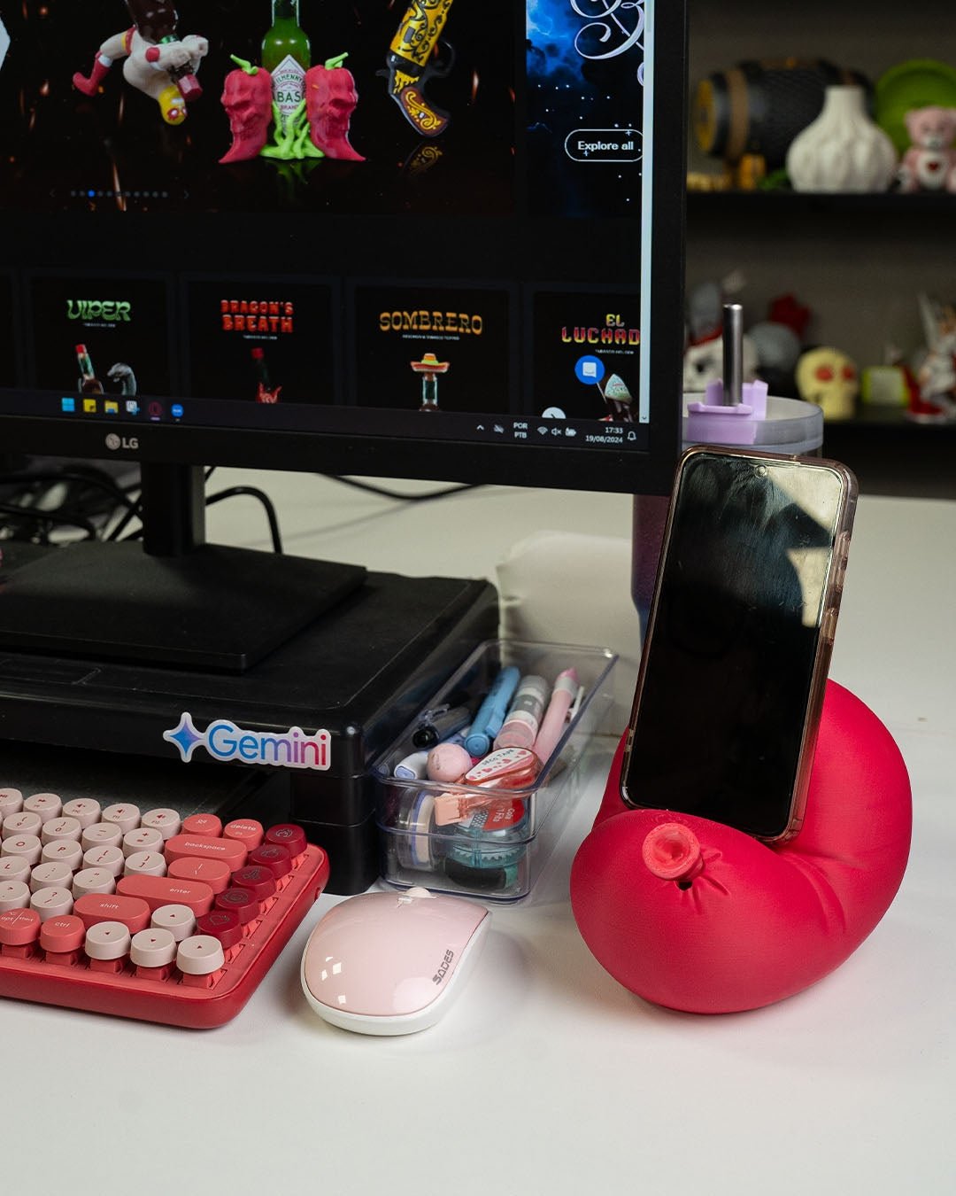 Roter Luftballon-Handyhalter mit Smartphone auf Gaming-Schreibtisch, Monitor und Deko-Regal im Hintergrund