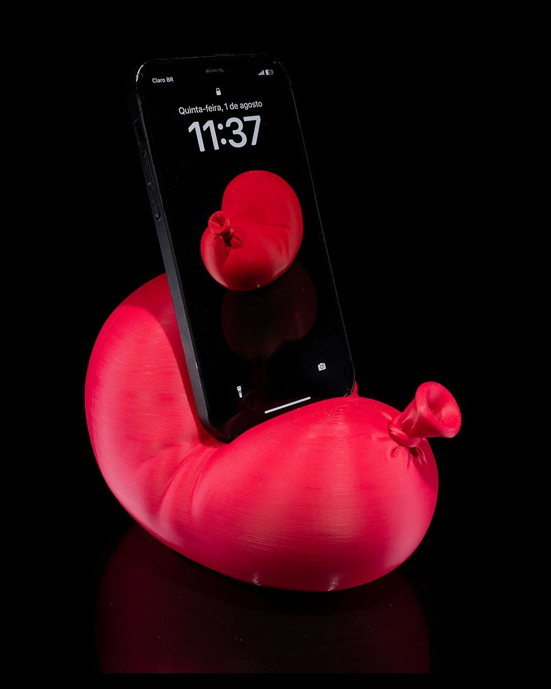 Roter Luftballon-Handyhalter mit eingestecktem Smartphone, schräg seitliche Ansicht mit Ballonknoten