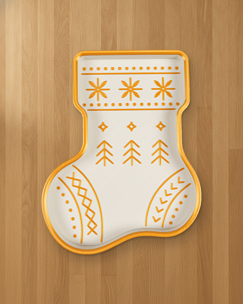 Nikolausstiefel-Schale in Weiß mit goldenem Rand und goldenem Muster aus Schneeflocken, Tannen und Rauten, von oben auf hellem Eichenholz