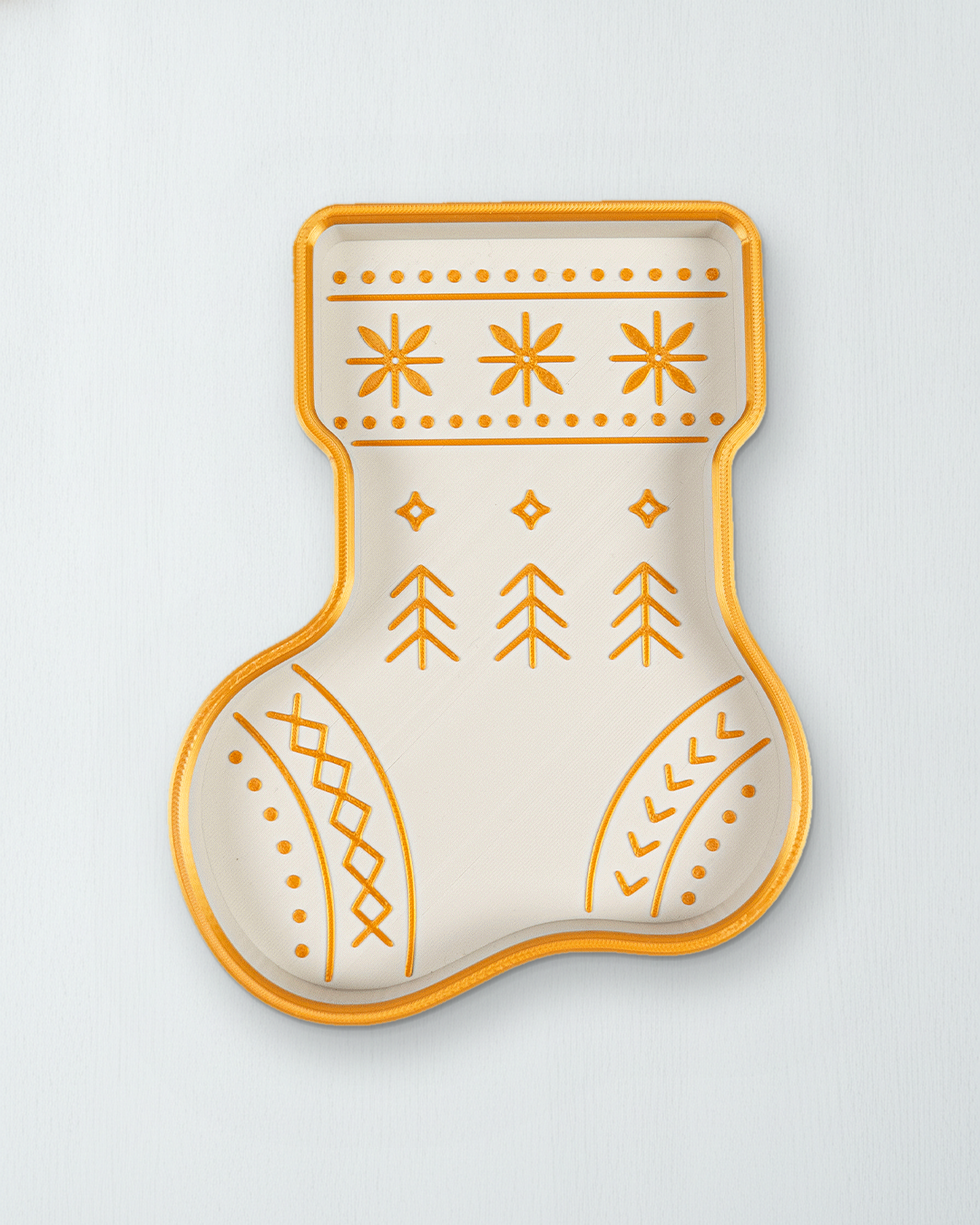 Nikolausstiefel-Schale in Weiß und Gold von oben auf einer weiß lasierten Holzfläche, goldener Rand mit Schneeflocken, Tannen und Rauten als Muster